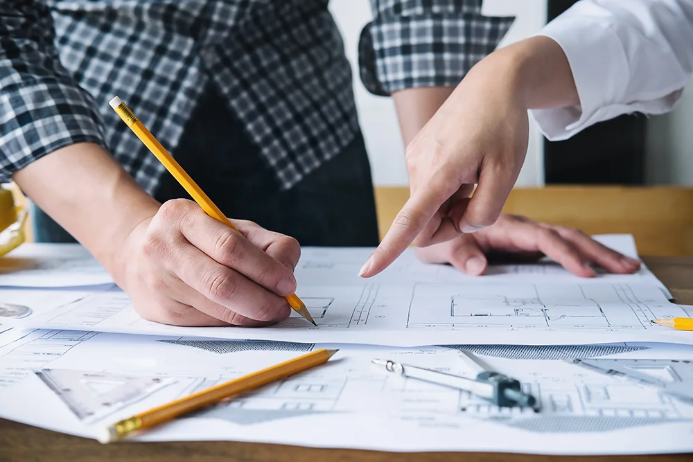 woman pointing at architectural plans